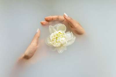 Woman holding floating flower in bath